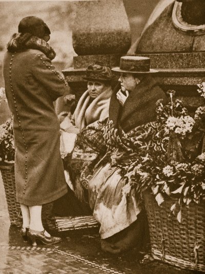 Flower sellers huddle and chat at Piccadilly Circus by English Photographer
